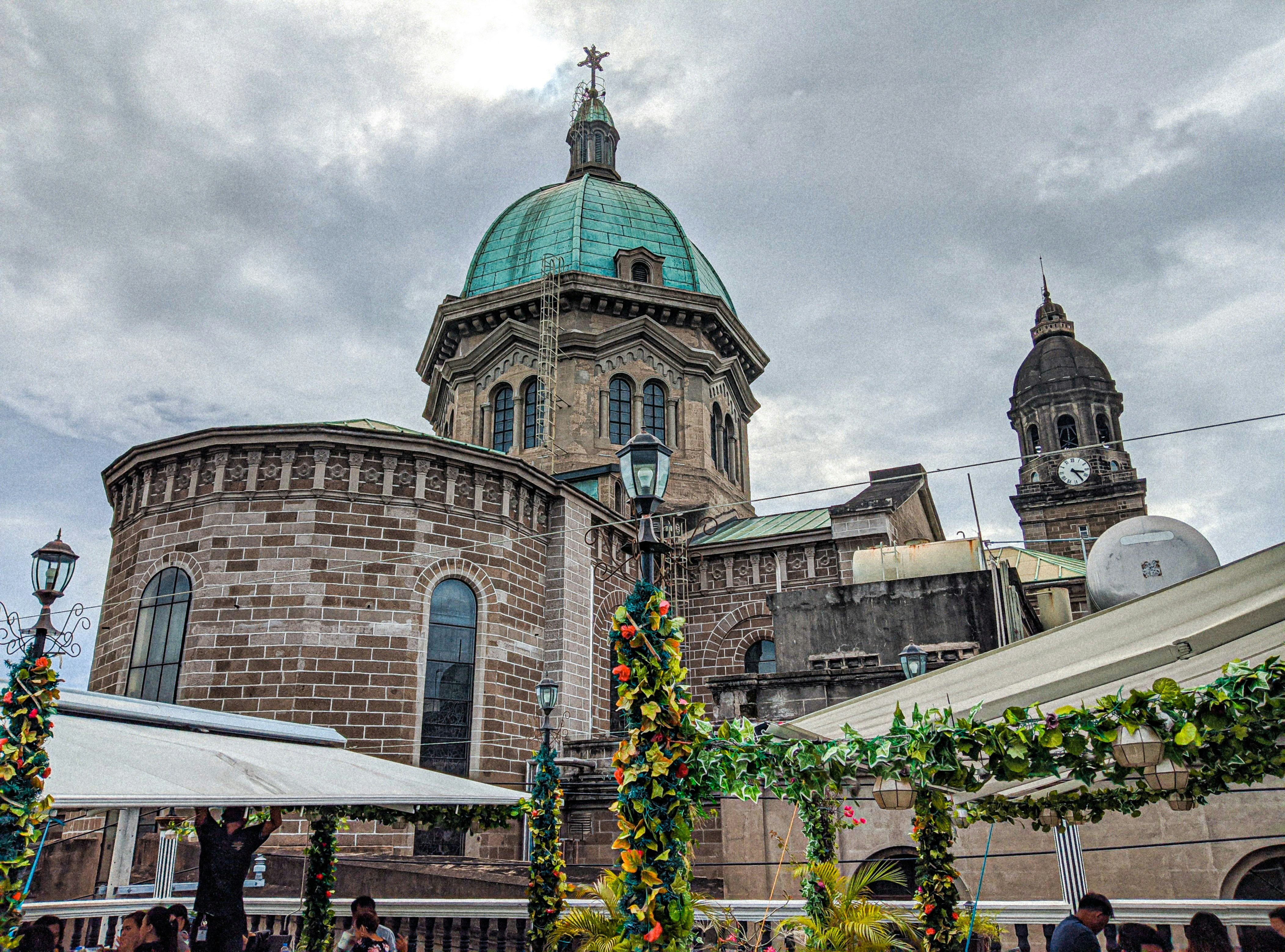 View of Manila Cathedral inside Intramuros with its iconic dome and clock tower, surrounded by colonial architecture and historic charm.