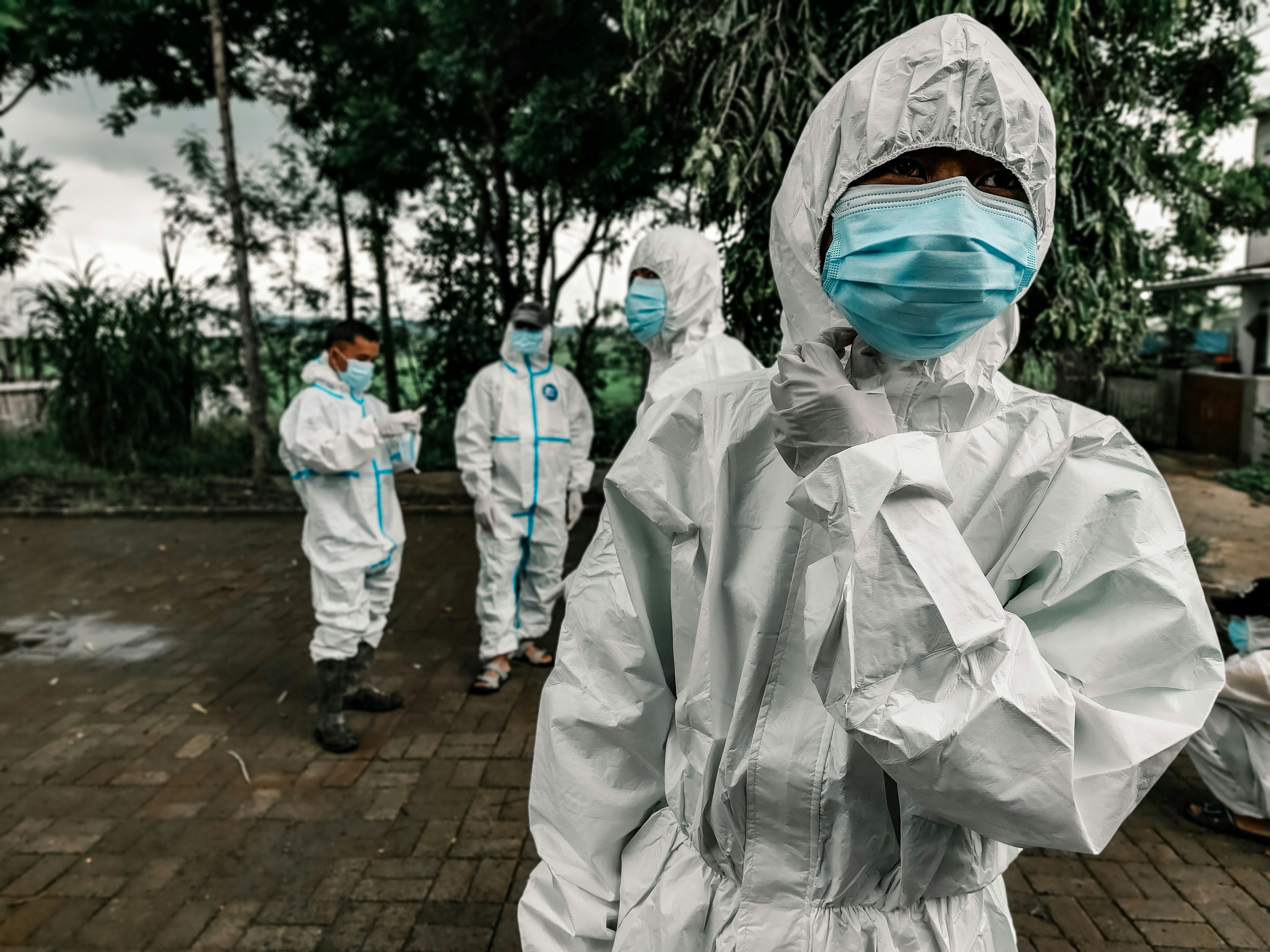 Healthcare workers in full-body PPE and face masks standing outdoors during the Covid-19 pandemic in the Philippines, symbolizing frontline safety measures and public health response.