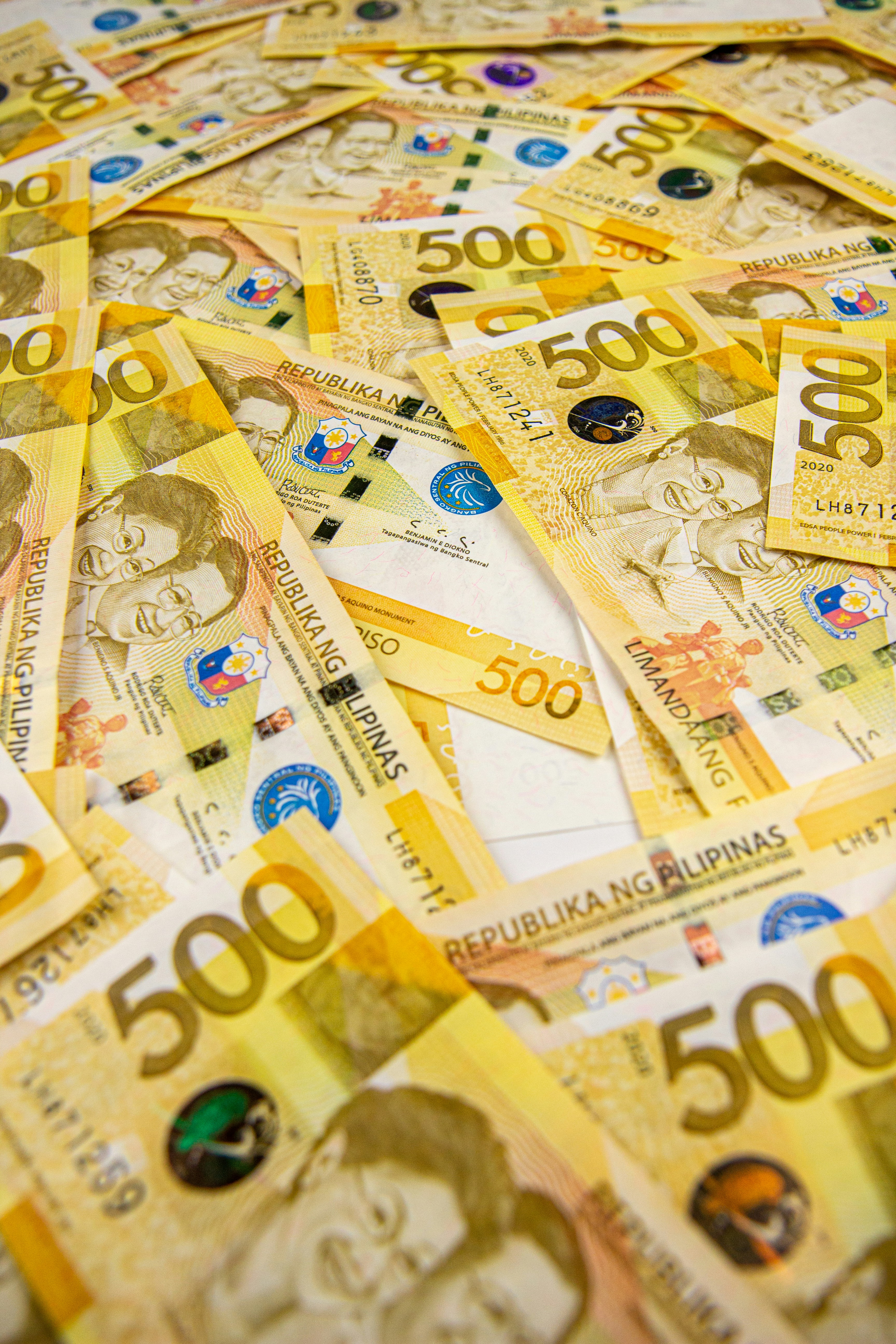 Scattered Philippine 500-peso bills featuring Benigno and Corazon Aquino, symbolizing systemic corruption, political patronage, and the role of money in regional and tribal power struggles across the Philippines.